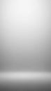 Empty studio backdrop with soft white and gray gradient lighting creating a subtle floor and wall transition for product placement Royalty Free Stock Photo