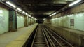 Empty subway platform with tracks extending into the darkness, signifying urban decay and neglect.