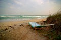 Empty sun lounger near stormy sea at windy weather