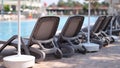 Empty sun loungers along pool in hotel in summer Royalty Free Stock Photo