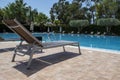 Empty Sun Loungers and Closed Umbrellas in the Morning by the Hotel Pool. Sunbeds Near the Swimming Pool in a Resort. Beautiful Royalty Free Stock Photo