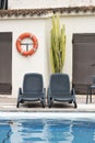 Empty sun loungers next to a swimming pool in an empty hotel due to coronavirus pandemics.