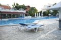 Empty sun loungers by the swimming pool with blue water at the hotel in the resort. no body Royalty Free Stock Photo