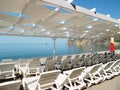 Empty sun loungers under a canopy on the beach. The beach area is empty. No people. White plastic sunbeds under the sun Royalty Free Stock Photo