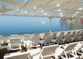 Empty sun loungers under a canopy on the beach. The beach area is empty. No people. White plastic sunbeds under the sun Royalty Free Stock Photo