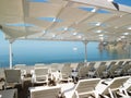 Empty sun loungers under a canopy on the beach. The beach area is empty. No people. White plastic sunbeds under the sun Royalty Free Stock Photo