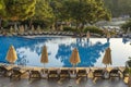 Empty sunbeds and closed parasols on morning, by the hotel pool. Swimming pool in luxury hotel resort near sea. Beautiful morning Royalty Free Stock Photo