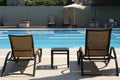 Empty sunbeds near outdoor swimming pool at resort Royalty Free Stock Photo