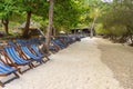 Empty sunbeds in row on seclude tropical sandy beach Royalty Free Stock Photo