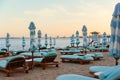 Empty sunbeds and umbrellas on a sandy beach near the sea Royalty Free Stock Photo