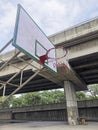 Empty sunlit basketball court in city park on hot sunny day under blue zenith sky. Bright sun in the sky. Sports, lifestyle, Royalty Free Stock Photo