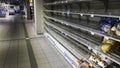 Empty supermarket shelves. Low supplies due to stockpiling by customers consumers due to covid 19 coronavirus Royalty Free Stock Photo