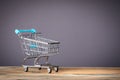 Empty supermarket shopping cart on grey background with copy space Royalty Free Stock Photo