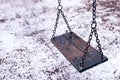 Empty swing on children playground under snow