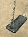 Empty swing on kids playground. vacant chain swing for children in a park on ground background. Close up photo. Corona virus