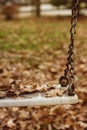 Empty swing with leaves in the autumn season Royalty Free Stock Photo