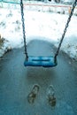 Empty swing in the playground in the park, wooden swing, wooden swing in winter, icicles on the swing Royalty Free Stock Photo