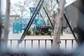 Empty swings on a New York City playground, on a rainy day