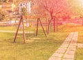 Empty swings at playground for child near children stairs slides equipment at sunset rays light Royalty Free Stock Photo