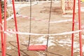 Empty swings on the playground fenced with tape for not using them during self-isolation due to coronavirus in 2020