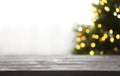 Empty table and blurred fir tree with yellow Christmas lights on background, bokeh effect Royalty Free Stock Photo