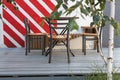 empty table and chair against white wall with red stripes Royalty Free Stock Photo