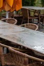 Empty table and empty chairs of summer restaurant or beer garden in summer on rainy day with raindrops and no guests, no income on Royalty Free Stock Photo