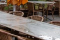 Empty table and empty chairs of summer restaurant or beer garden in summer on rainy day with raindrops and no guests, no income on