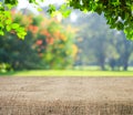 Empty table covered with sackcloth over blurred trees with bokeh background