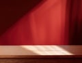 Empty table on dark red wall. Background with window light and shadow. Mockup for presentation, branding products, cosmetics, food Royalty Free Stock Photo
