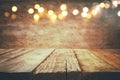 empty table in front of Christmas warm gold garland lights