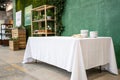 Empty Table with Linen Tablecloth Over Green Concrete Wall Royalty Free Stock Photo