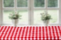 Empty table product. Closeup of a empty red tablecloth or napkin over abstract blurred bright windows background. Template for Royalty Free Stock Photo