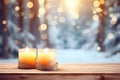 Empty table top with burning candles on blurred festive winter forest background Royalty Free Stock Photo