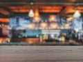 The empty table wooden board in front of the background is blurred. Brown wood perspective over the blur in the bar shop - can be Royalty Free Stock Photo