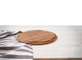 Empty tablecloth on wood table and pizza cutting board isolated on white background. Selective focus. Place for food. Top view. Royalty Free Stock Photo