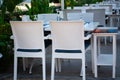 Empty tables and chairs in outdoor restaurant. Street cafe on the promenade in resort town. Summer seasoal cafe Royalty Free Stock Photo