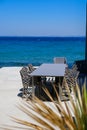 Empty tables and chairs of a restaurant on a terrace overlooking the sea. Royalty Free Stock Photo