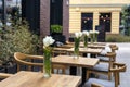 Empty tables with flowers in outdoor cafe or restaurant. Tables and chairs at sidewalk cafe. Touristic setting, tulips on cafe. Royalty Free Stock Photo