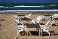 The empty tables and shite chairs on sea beach
