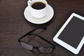 Empty tablet and a cup of coffee on the black desk. glasses Royalty Free Stock Photo