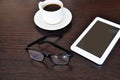 Empty tablet and a cup of coffee on the black desk. glasses Royalty Free Stock Photo