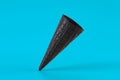 Empty, tasty black wafer cone for ice cream on blue background. Concept of food, treats. Mockup, template for your