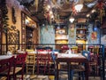 Empty tavern indoors seating area with wooden chairs, tables, and vintage decoration