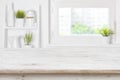 Empty textured wooden table and kitchen window shelves blurred background