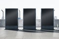 Empty three black outdoor billboard screens on bright city background. Advertisement and commercial concept. Mock up