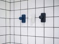 Empty three modern towel hooks, blue and white hanging on white grid wall. Royalty Free Stock Photo