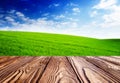 Empty Tiles At Wooden Tabel Landscape With Green Grass And Blue Sky With Clouds On The Farm In Beautiful Summer Sunny Day. Clean,