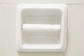 Empty toilet paper roll mounted on a tiled wall Royalty Free Stock Photo