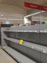 Empty toilet paper shelves in supermarket after panic buying due to outbreaking coronavirus, translation:`There is no stock availa